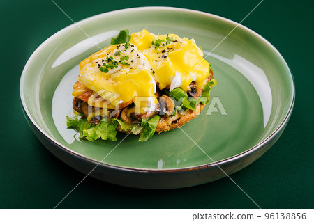 Tasty egg Benedict on green plate 96138856