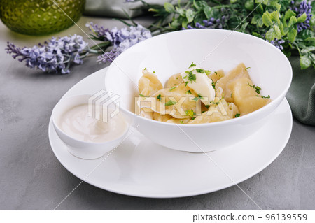 Delicious cooked dumplings and sour cream Delicious cooked dumplings and sour cream 96139559