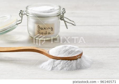Baking soda in a wooden spoon on a light wooden table. Baking soda in a wooden spoon on a light wooden table. 96140571