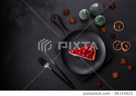 Homemade tasty cheesecake with jelly and raspberry berries on a black plate 96143625