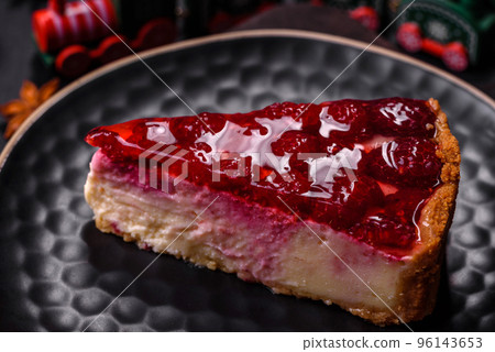 Homemade tasty cheesecake with jelly and raspberry berries on a black plate Homemade tasty cheesecake with jelly and raspberry berries on a black plate 96143653