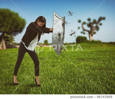 Woman defends herself from the attack of mosquitoes with a shield 96143909