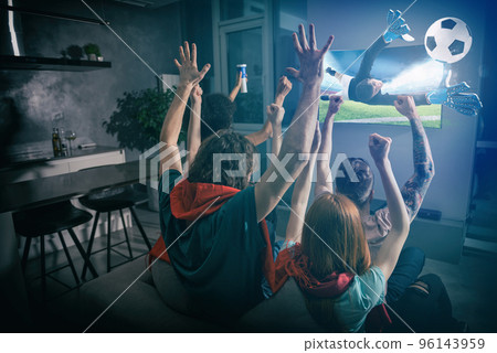 Group of friends watch the game together on television and rejoice 96143959