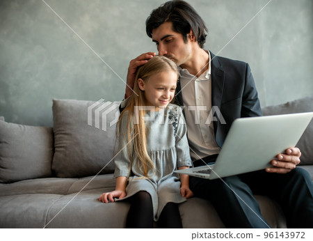 Happy little girl watching a movie on the computer with her father Happy little girl watching a movie on the computer with her father 96143972