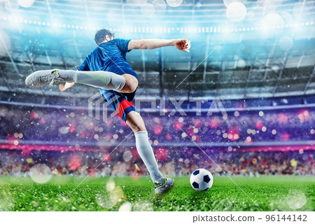 Football scene at night match with player kicking the ball with power. Football scene at night match with player kicking the ball with power. 96144142
