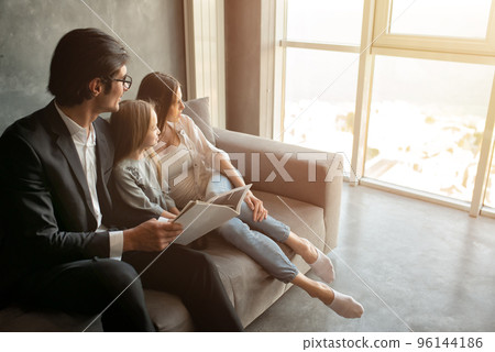 Happy little girl reads a book with her parents Happy little girl reads a book with her parents 96144186