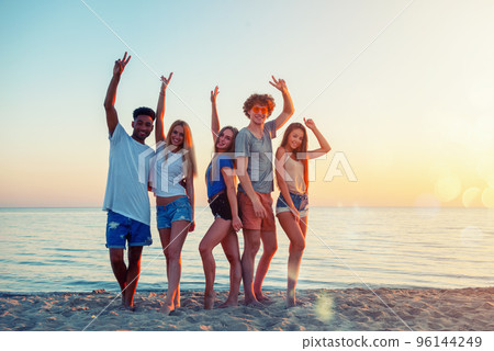 Group of friends having fun on the beach. Concept of summertime Group of friends having fun on the beach. Concept of summertime 96144249