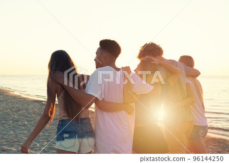Group of friends having fun on the beach. Concept of summertime Group of friends having fun on the beach. Concept of summertime 96144250