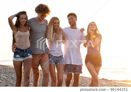 Group of friends having fun on the beach. Concept of summertime Group of friends having fun on the beach. Concept of summertime 96144251
