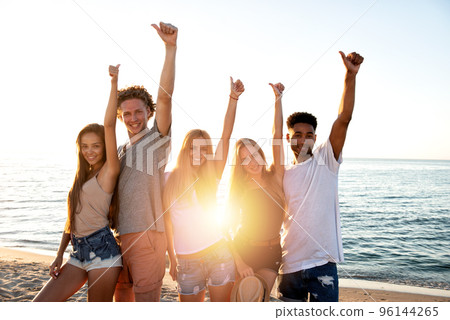 Group of friends having fun on the beach. Concept of summertime Group of friends having fun on the beach. Concept of summertime 96144265