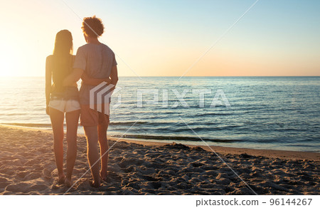 Couples during a sunrise at the beach Couples during a sunrise at the beach 96144267