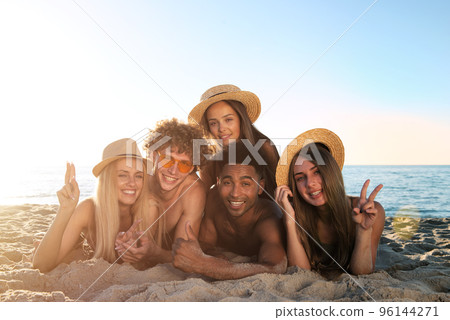 Group of friends having fun on the beach. Concept of summertime Group of friends having fun on the beach. Concept of summertime 96144271