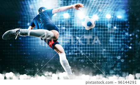 Football scene at night match with player kicking the ball with power Football scene at night match with player kicking the ball with power 96144291