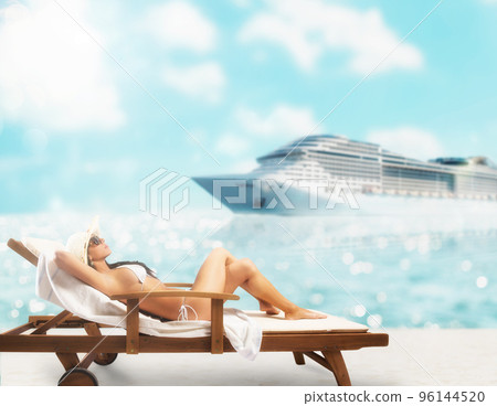 Beautiful girl sitting on a deck chair at the beach at sunset with cruiseship on background Beautiful girl sitting on a deck chair at the beach at sunset with cruiseship on background 96144520