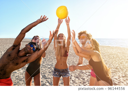 Group of friends playing at beach volley at the beach 96144556