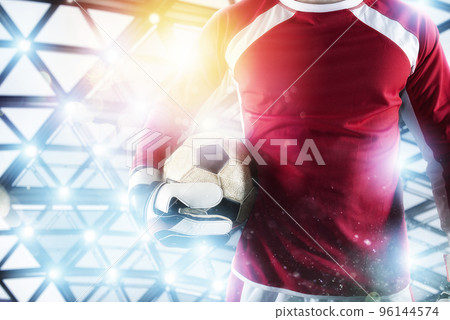 Goalkeeper holds the ball in the stadium during a football game. 96144574