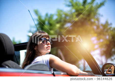 Young woman in cabriolet car departs for the summer holidays 96144626