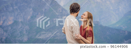BANNER, LONG FORMAT Man and woman happy couple tourists on background of Breathtaking panoramic view of the Grlo Sokolovo gorge in Montenegro. In the foreground is a mountain, the flat side of which 96144906