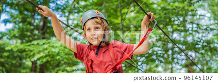BANNER, LONG FORMAT Happy child in a helmet, healthy teenager school boy enjoying activity in a climbing adventure park on a summer day Portrait of a disgruntled girl sitting at a cafe table BANNER, LONG FORMAT Happy child in a helmet, healthy teenager school boy enjoying activity in a climbing adventure park on a summer day Portrait of a disgruntled girl sitting at a cafe table 96145107