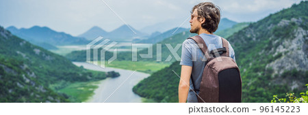 BANNER, LONG FORMAT Man tourist in the background Canyon of Rijeka Crnojevica river near the Skadar lake coast. One of the most famous views of Montenegro. River makes a turn between the mountains and 96145223