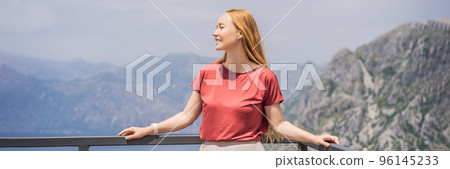 BANNER, LONG FORMAT Woman tourist enjoys the view of Kotor. Montenegro. Bay of Kotor, Gulf of Kotor, Boka Kotorska and walled old city. Travel to Montenegro concept. Fortifications of Kotor is on 96145233