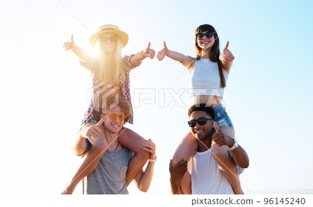 Happy smiling couples playing at the beach 96145240