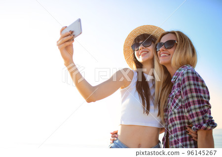 Happy group of friend makes a selfie with a mobile phone. 96145267