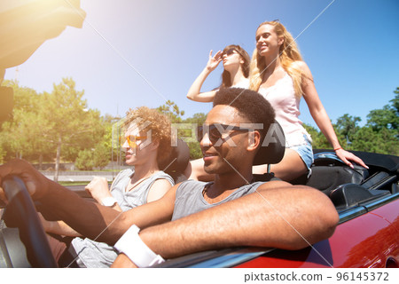 Young friends ready to travel by the car Young friends ready to travel by the car 96145372