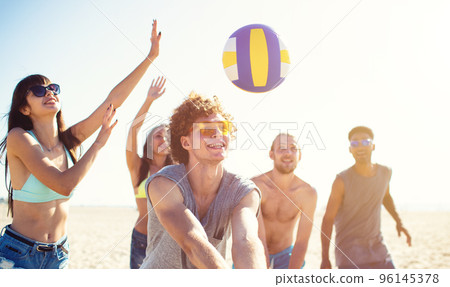 Group of friends playing at beach volley at the beach Group of friends playing at beach volley at the beach 96145378