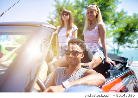 Young friends ready to travel by the car Young friends ready to travel by the car 96145380