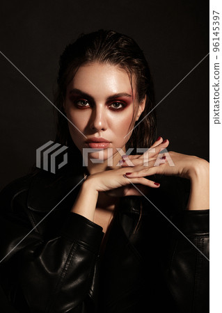 Portrait of a beautiful woman in a rock style image with creative makeup and hairstyle. Portrait of a beautiful woman in a rock style image with creative makeup and hairstyle. 96145397