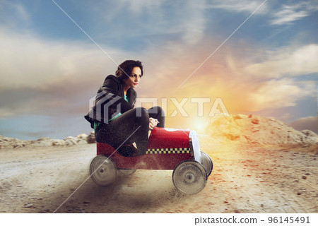 Businesswoman drives a toy car. Concept of competition and determination Businesswoman drives a toy car. Concept of competition and determination 96145491
