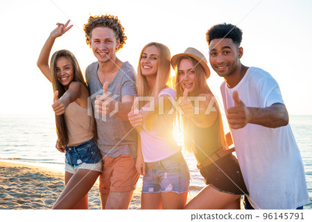 Group of friends having fun on the beach. Concept of summertime Group of friends having fun on the beach. Concept of summertime 96145791