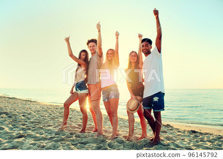 Group of friends having fun on the beach. Concept of summertime Group of friends having fun on the beach. Concept of summertime 96145792