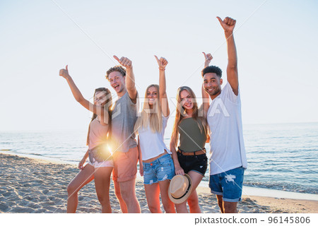 Group of friends having fun on the beach. Concept of summertime Group of friends having fun on the beach. Concept of summertime 96145806