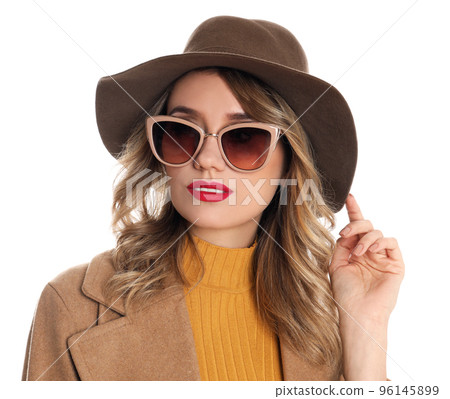 Young woman wearing stylish sunglasses and hat on white background 96145899