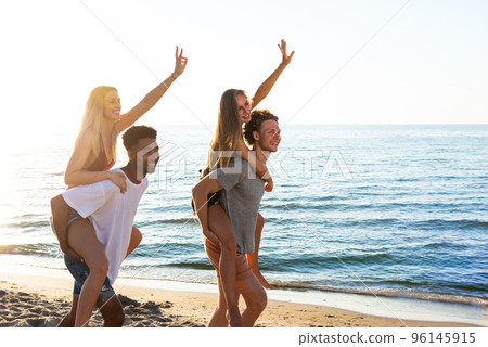 Happy smiling couples playing at the beach 96145915