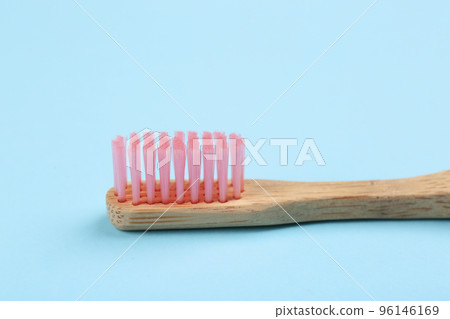 Toothbrush made of bamboo on light blue background, closeup 96146169