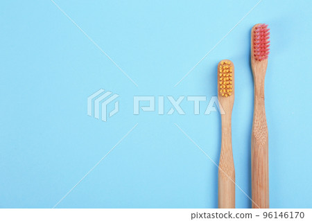 Toothbrushes made of bamboo on light blue background, flat lay. Space for text Toothbrushes made of bamboo on light blue background, flat lay. Space for text 96146170