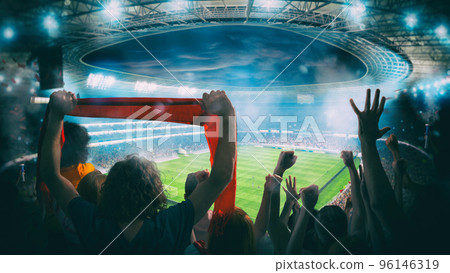 Football scene at night match with with cheering fans at the stadium 96146319