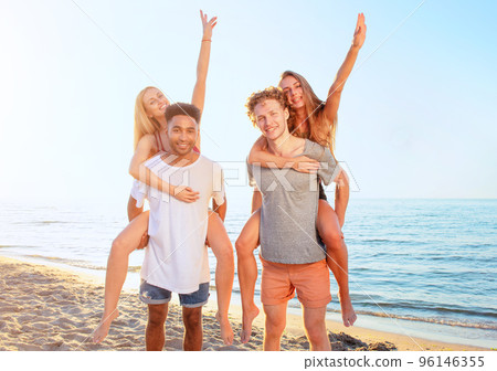 Happy smiling couples playing at the beach 96146355