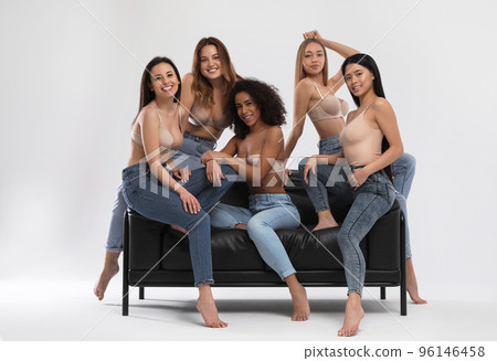 Group of women with different body types in jeans and underwear taking selfie against light Group of women with different body types in jeans and underwear taking selfie against light 96146458