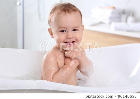 Cute little baby in bathtub at home 96146655