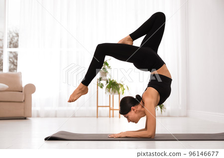 Professional young acrobat practicing yoga at home Professional young acrobat practicing yoga at home 96146677