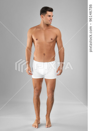 Handsome man in white underwear on light grey background Handsome man in white underwear on light grey background 96146786