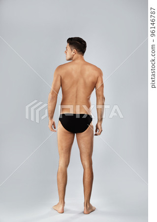 Handsome man in black underwear on light grey background, back view Handsome man in black underwear on light grey background, back view 96146787