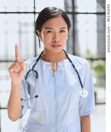 Portrait of asian female doctor showing thumbs up and smiling Portrait of asian female doctor showing thumbs up and smiling 96146849