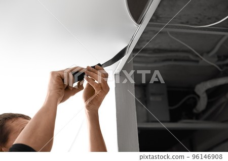 Repairman installing white stretch ceiling in room, closeup 96146908