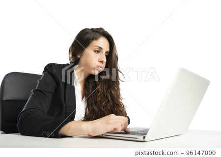 Bored woman snorts in the office while working on the laptop 96147000
