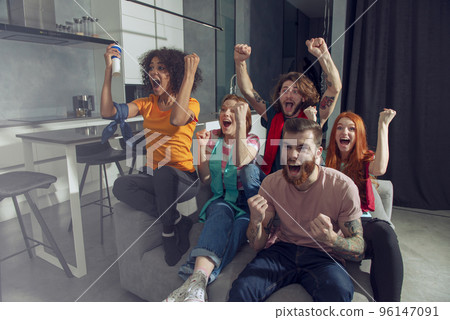Happy friends of football fans watching soccer on tv and celebrating victory. 96147091